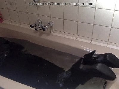 Pantalon sexy moulant, bottines et talons dans la salle de bain.