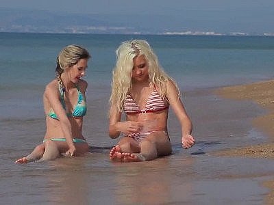 Deux jeunes filles en bikini se mettent nues sur la plage.